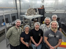 Advanced Mass Metrology alumni (Class of 2023) posing in front NIST's Kibble Balance.