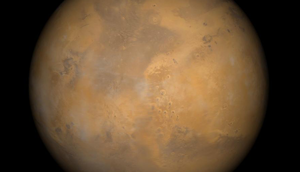 Color-enhanced photo of Mars shows the planet with patches of orange and brown. 