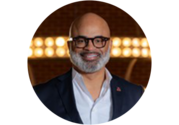 Professional headshot of Quintin D. Jones, a bald man with a mustache, beard, and glasses, wearing a suit.