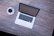 Image of a laptop and cup of coffee on a table