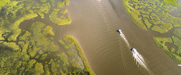 Aerial view of boats navigating waters in a marsh on the Louisiana coast. Photo: State of Louisiana