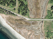An aerial view of a roadway crossing a river outlet where the project is located.