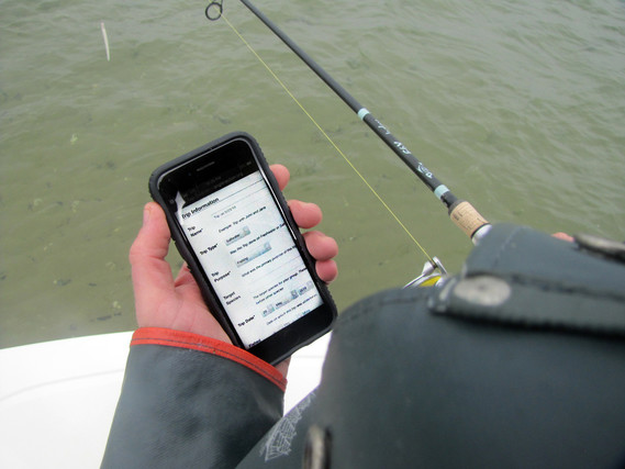 Angler looking at fishing app on his iPhone