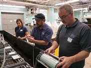 abriella Dipreta, Dave Veilleux, and Sean Grace collect data with a fluorometer during an ocean acidification experiment.