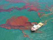 A ship on water with oil on the surface.