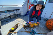Student Danny Dorado cleans off hydrophones aboard a research vessel.