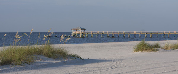 On a Mississippi Gulf Coast beach looking out to the water with a pier.