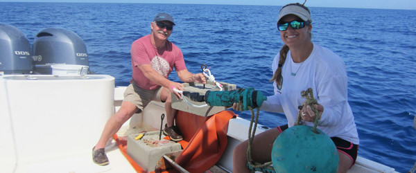 Two scientists prepare to deploy an acoustic receiver to monitor tagged fish.