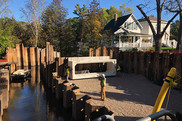 Workers install a large concrete structure in a stream