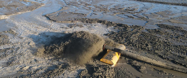 A pipe expelling water and sediment at a construction site