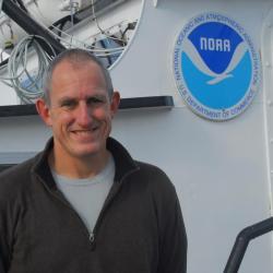 Jon Hare standing by a small research vessel