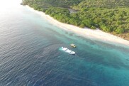 A tropical coastline with a large white boat halfway submerged in shallow water. Credit: U.S. Coast Guard