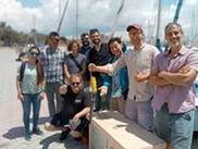 group around a temperature sensor, displaying it proudly on a sunny day at a stone pier
