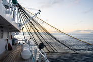 Fishing boat putting out a net at sunrise. Credit iStock