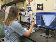 Woman in a lab looking at a shark vertebra