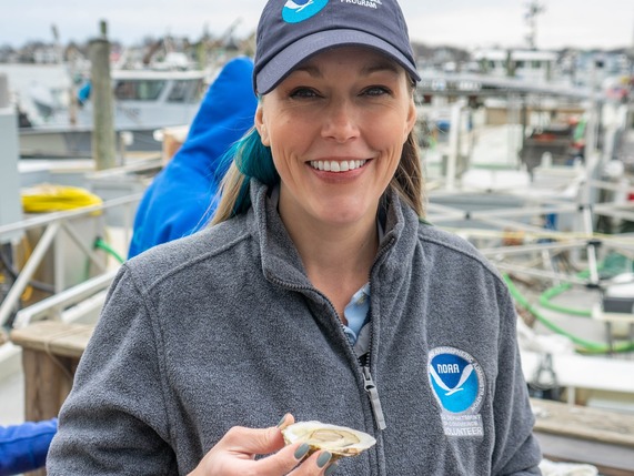 Danielle Blacklock holding a raw oyster at Copps Island Oysters in Connecticut (Credit: NOAA Fisheries.)