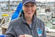 Danielle Blacklock holding a raw oyster at Copps Island Oysters in Connecticut