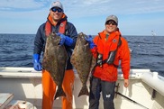 two men holding flatfish 