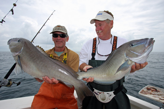 Fishermen holding fish. Credit: Ken Neill
