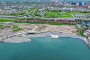 Aerial view of construction underway on a shoreline in an urban park.