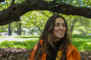 young woman with long brown hair in a greenspace