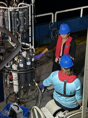 scientists ondeck of ship with water sampling gear