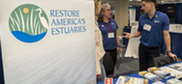 Man and woman at conference table with Restore America’s Estuaries banner.