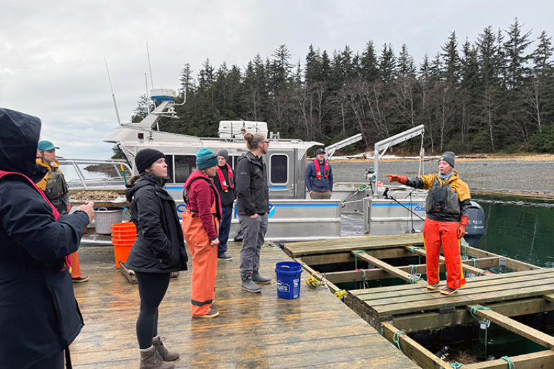 NOAA Fisheries staff on a dock in Alaska on a cloudy day.
