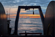 The sun sets over the net reel of the NOAA ship Bell M. Shimada. Credit: NOAA Fisheries