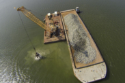 Hard substrate is moved from a barge into the Piankatank River, part of NOAA's Middle Peninsula Habitat Focus Area in Virginia.