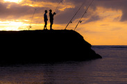 Angling from shore at sunset