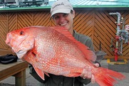 Women holding a large red snapper.