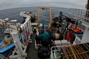 A net is slowly lowered into the water from a vessel