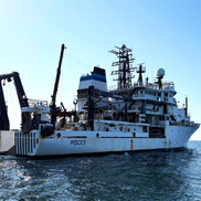 Large white oceanographic vessel at sea with PISCES written on the starboard side