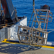 Large metal camera sled system being pulled onto stern of a ship