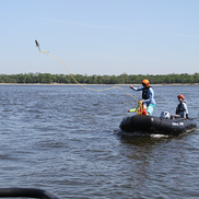 A responder throws a grapple out of a small boat at sea