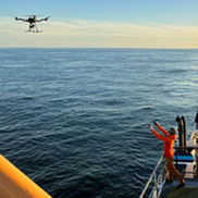 Scientist catching a drone with sample on the stern of a ship