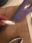 A hot glue gun is used to glue the paper tubes together. 