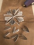 Many more pieces of cut paper tube are glued together to make a snowflake.
