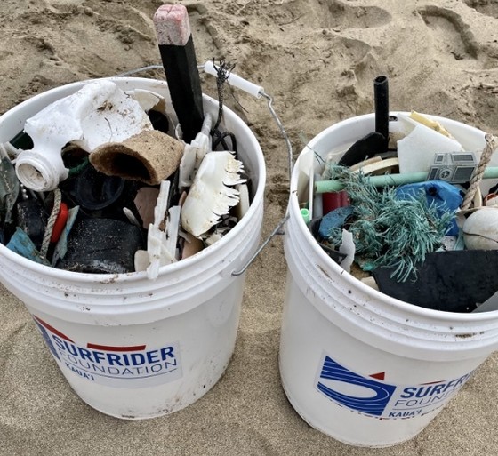 Two buckets filled with marine debris removed from a beach.