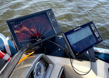 Side-scan and live sonar screen devices mounted on a survey vessel.