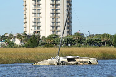 An abandoned and derelict vessel submerged in a harbor.