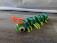 A caterpillar with googly eyes and orange antennae made of pipe cleaners.