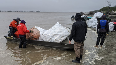 U.S. Forest Service staff removing debris and loading it into boats for sorting and disposal.