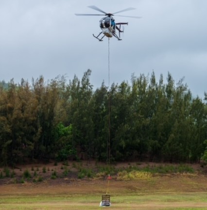 A super sack full of marine debris is airlifted by a helicopter.