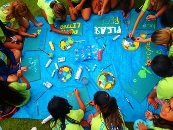 A group of students painting "Recycle" signs. 