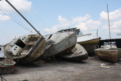 Abandoned derelict vessels piled on top of one another and washed ashore.  