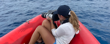 woman on a boat in the ocean with binoculars 