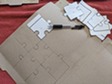 Jigsaw puzzle pieces laid out and outlined on the back of a cardboard cereal box.