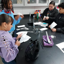 Four children cutting paper strips for a project